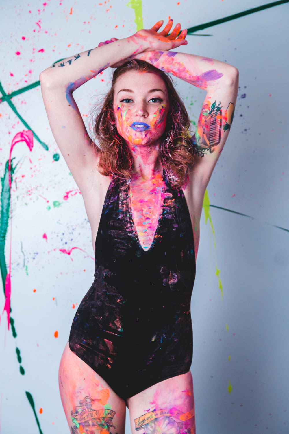 a woman in a bodysuit covered in paint