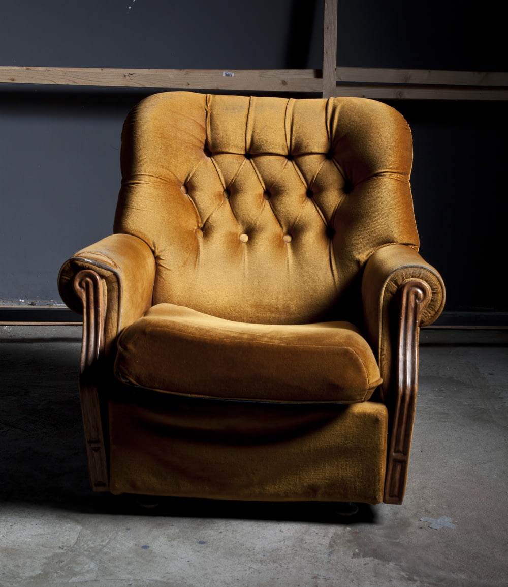 갈색 푹신한 안락 의자의 얕은 초점 사진