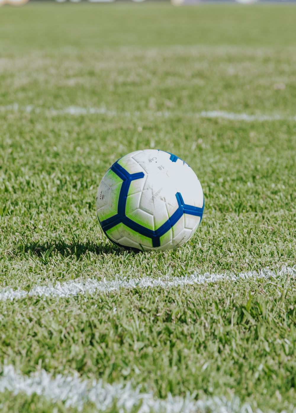 white, blue, and green soccer ball on field