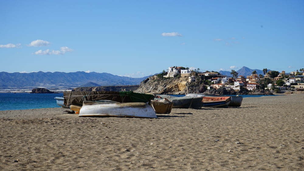 boats docked on sand seashore during day