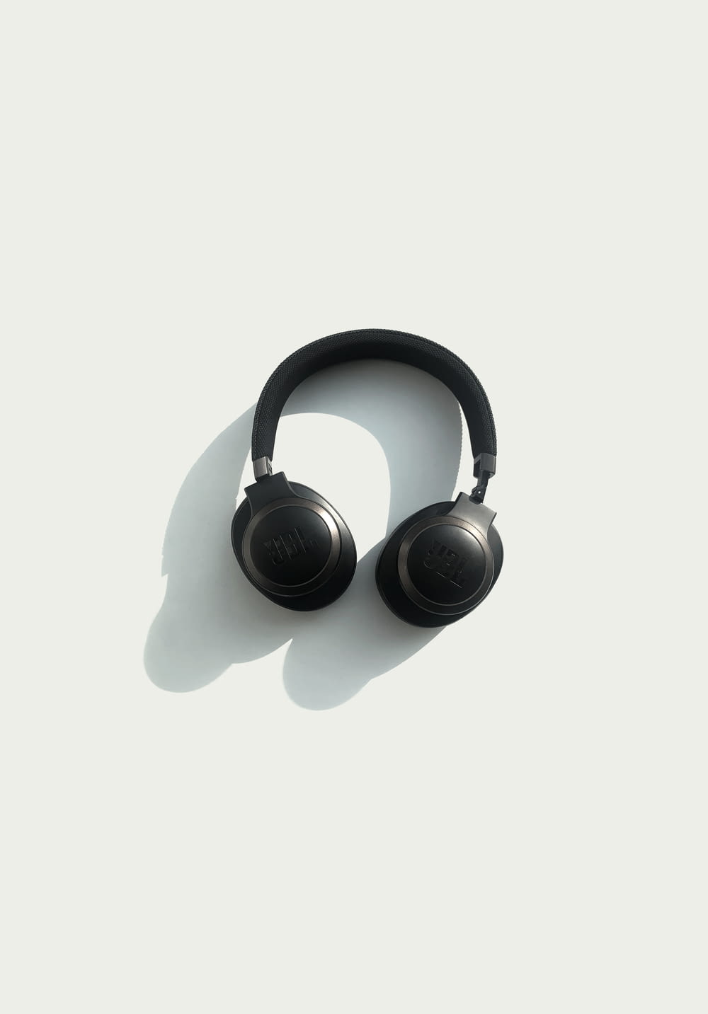 black JBL corded headphones on white panel