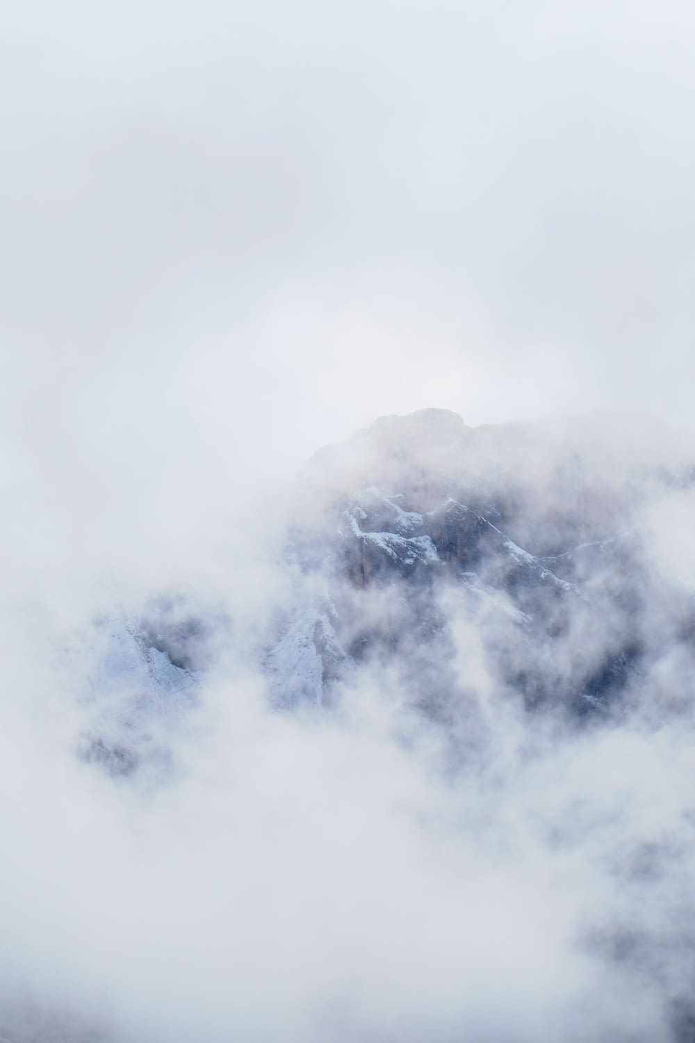 a bird flying through the clouds in the mountains