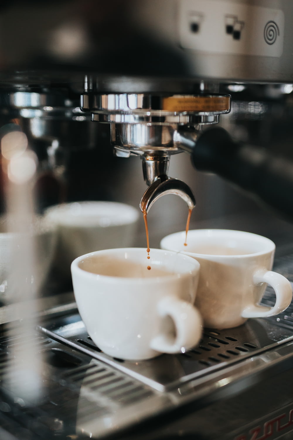 Dos tazas de café que se vierten en una máquina de café