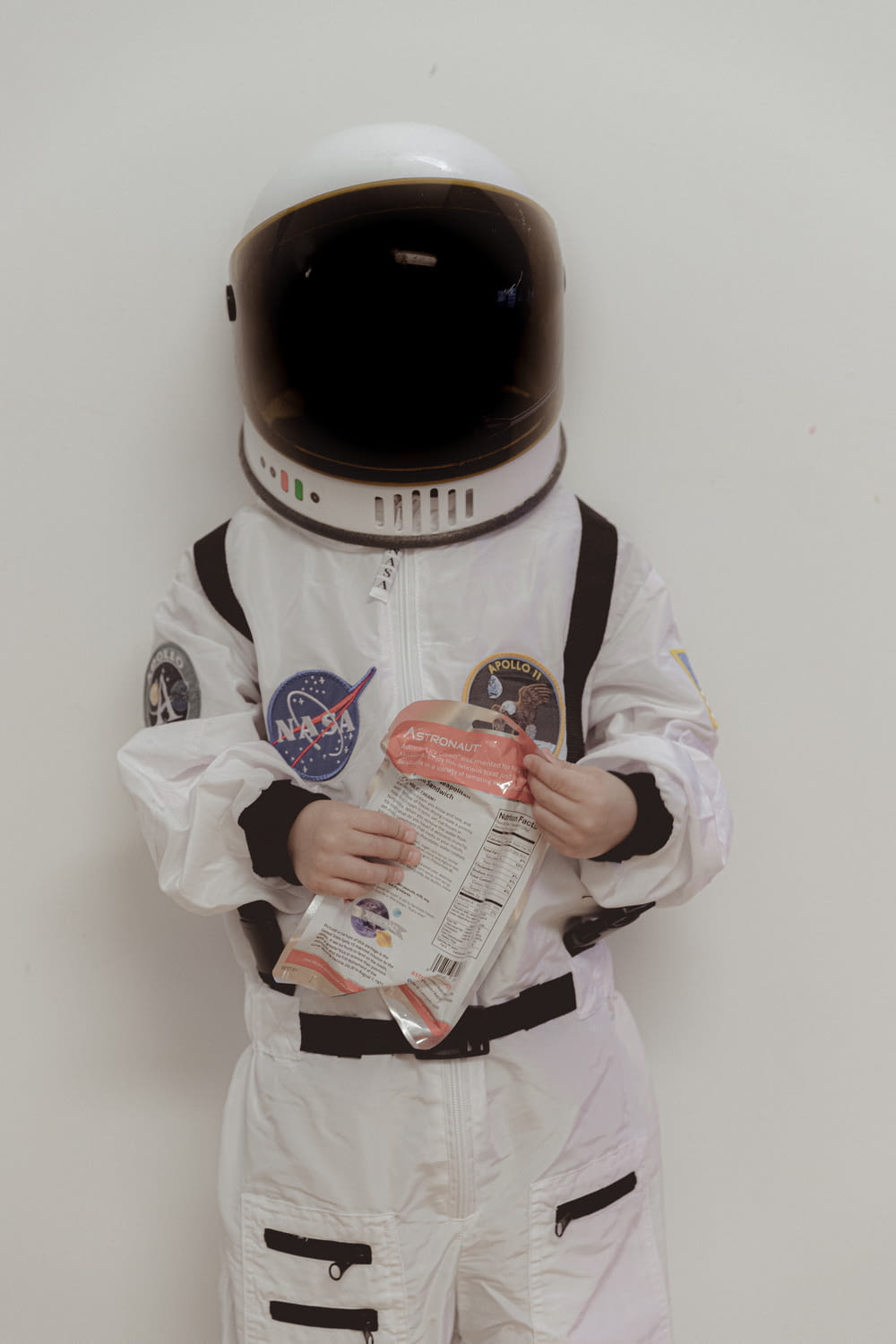 a man in a space suit holding a newspaper