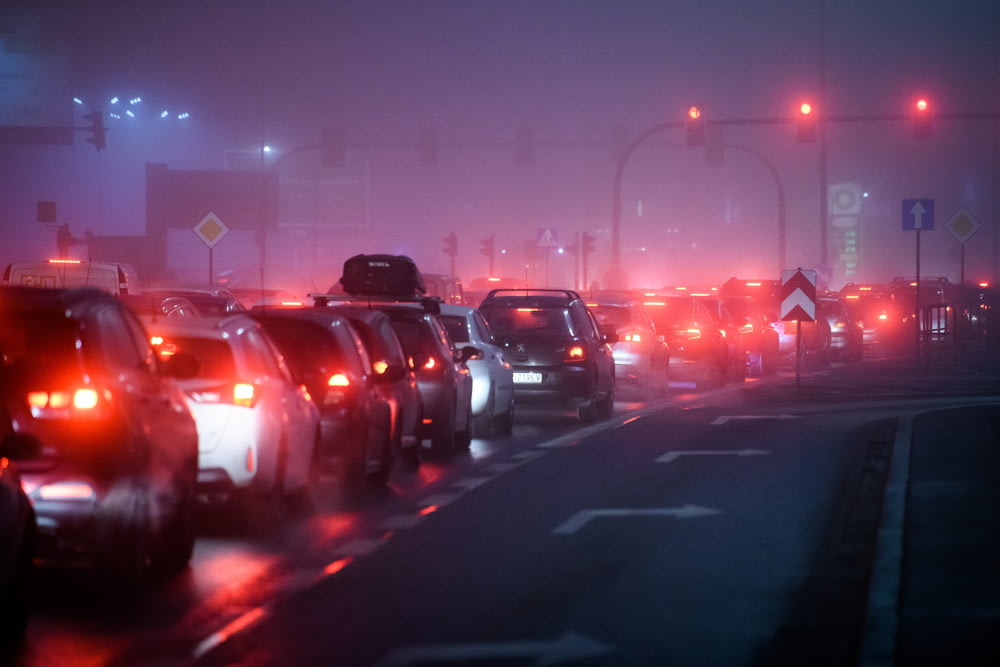 Una calle de la ciudad con niebla llena de mucho tráfico