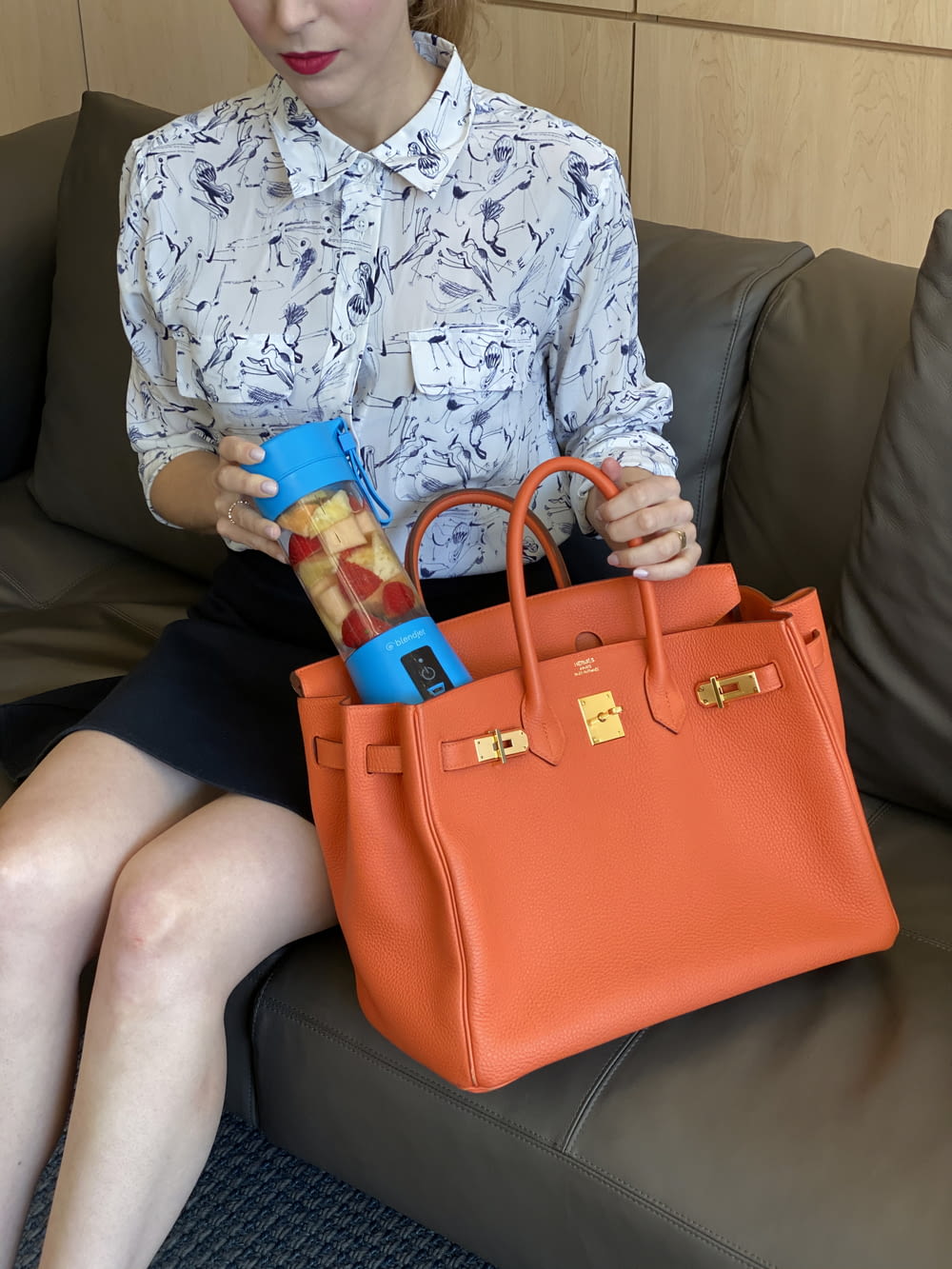 a woman sitting on a couch holding a purse