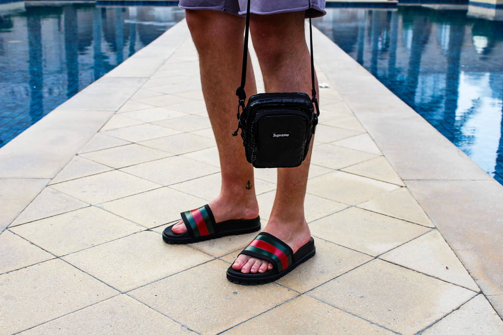 person wearing black and red hiking sandals