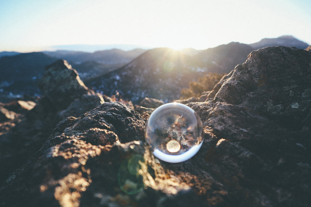 sfera di vetro trasparente su roccia marrone