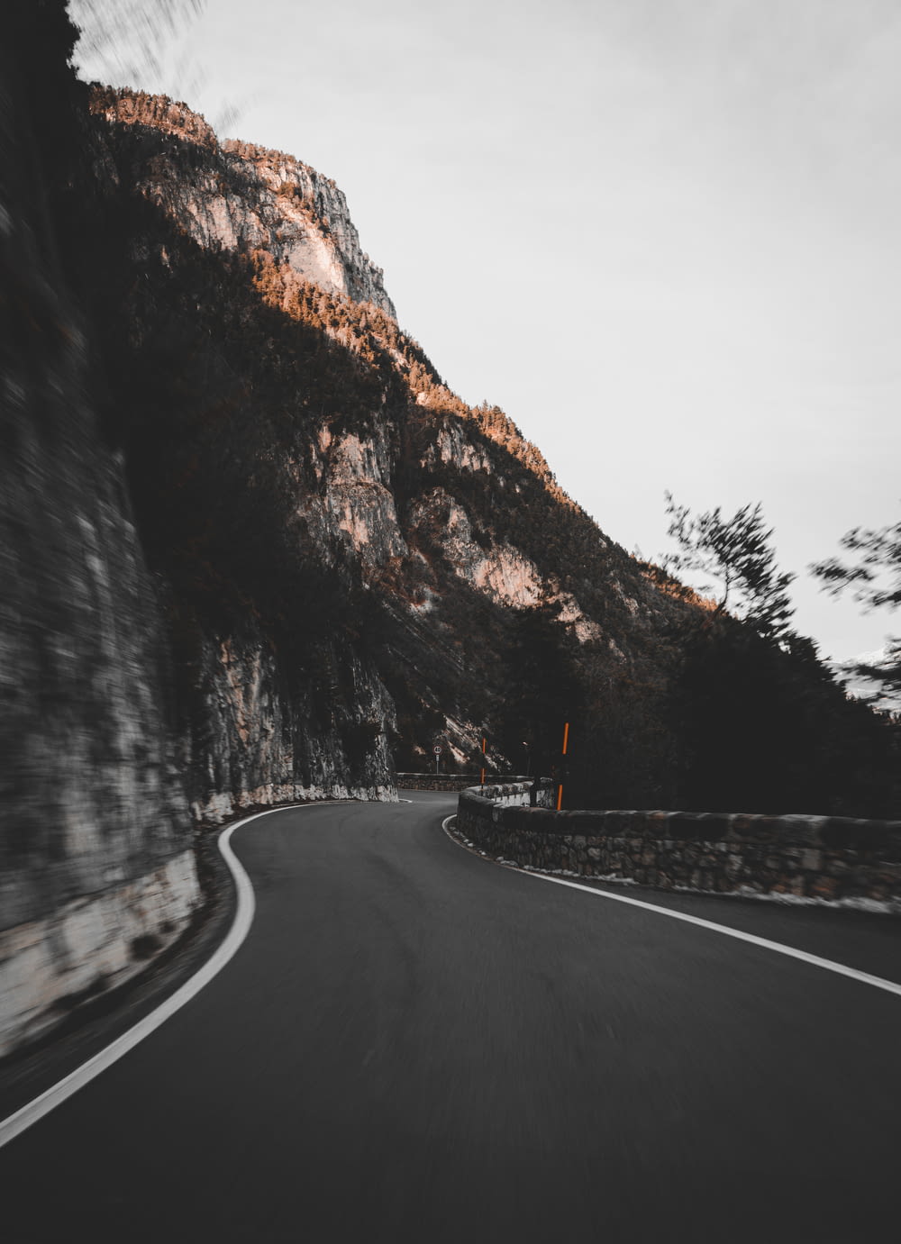 Strada asfaltata nera tra la montagna rocciosa marrone durante il giorno