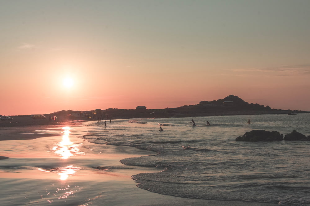 personnes sur la plage au coucher du soleil