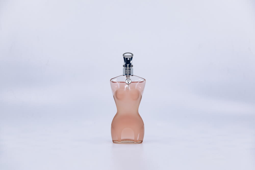 orange glass perfume bottle on white surface