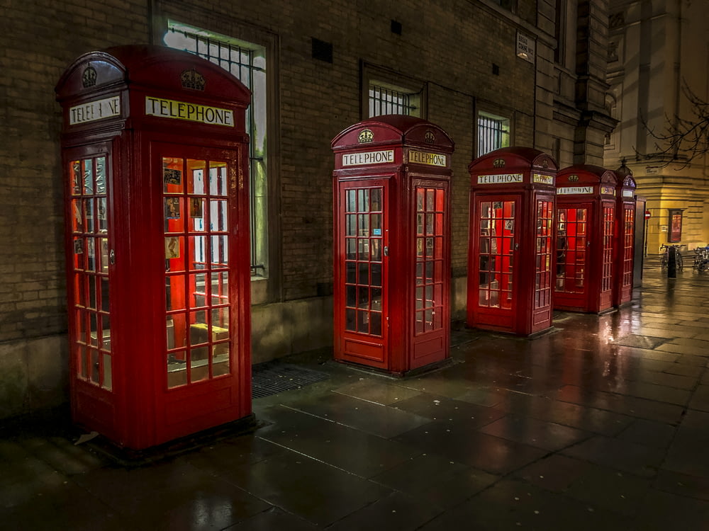 red telephone booth on brown brick floor