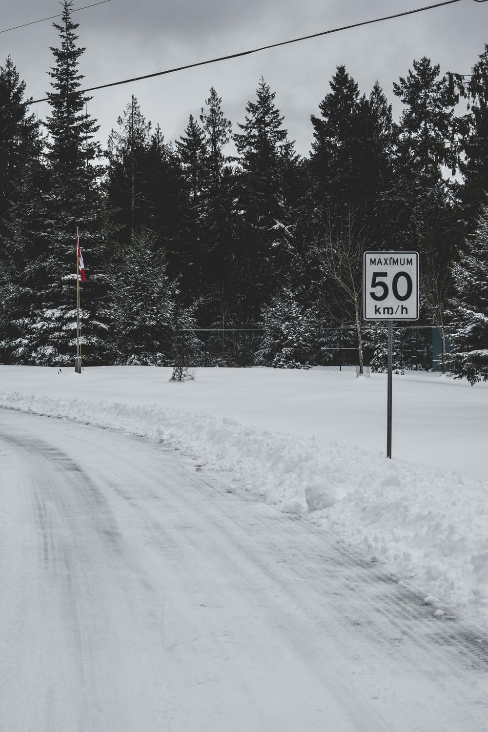 black and white stop sign on snow covered ground