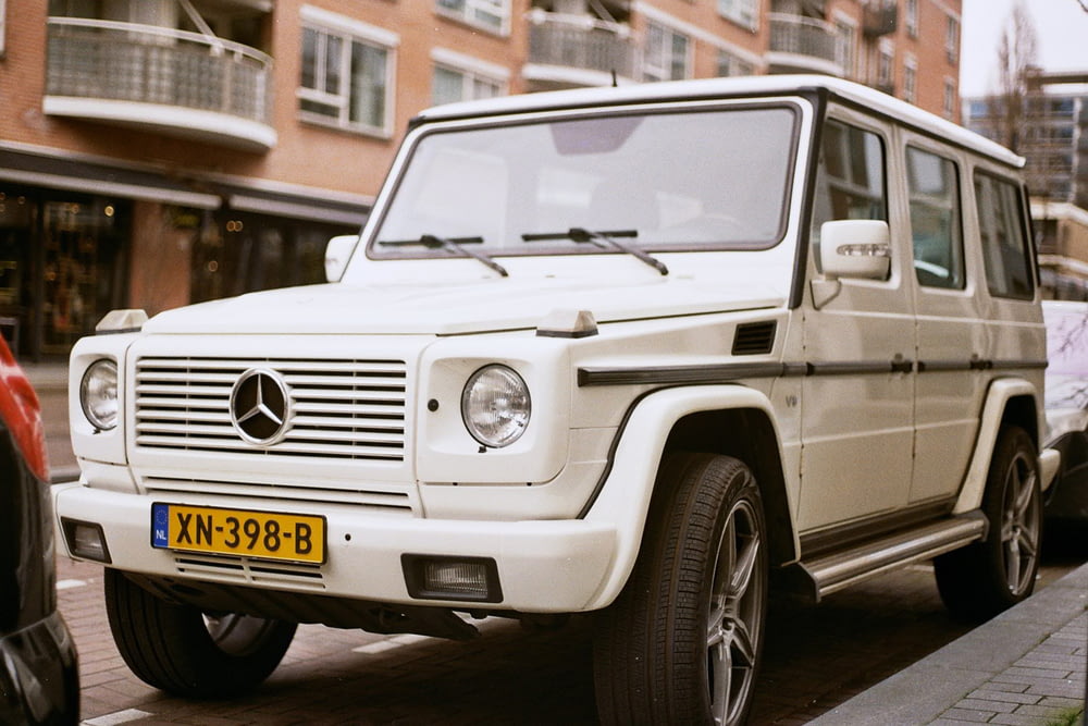 white mercedes benz g class on road during daytime