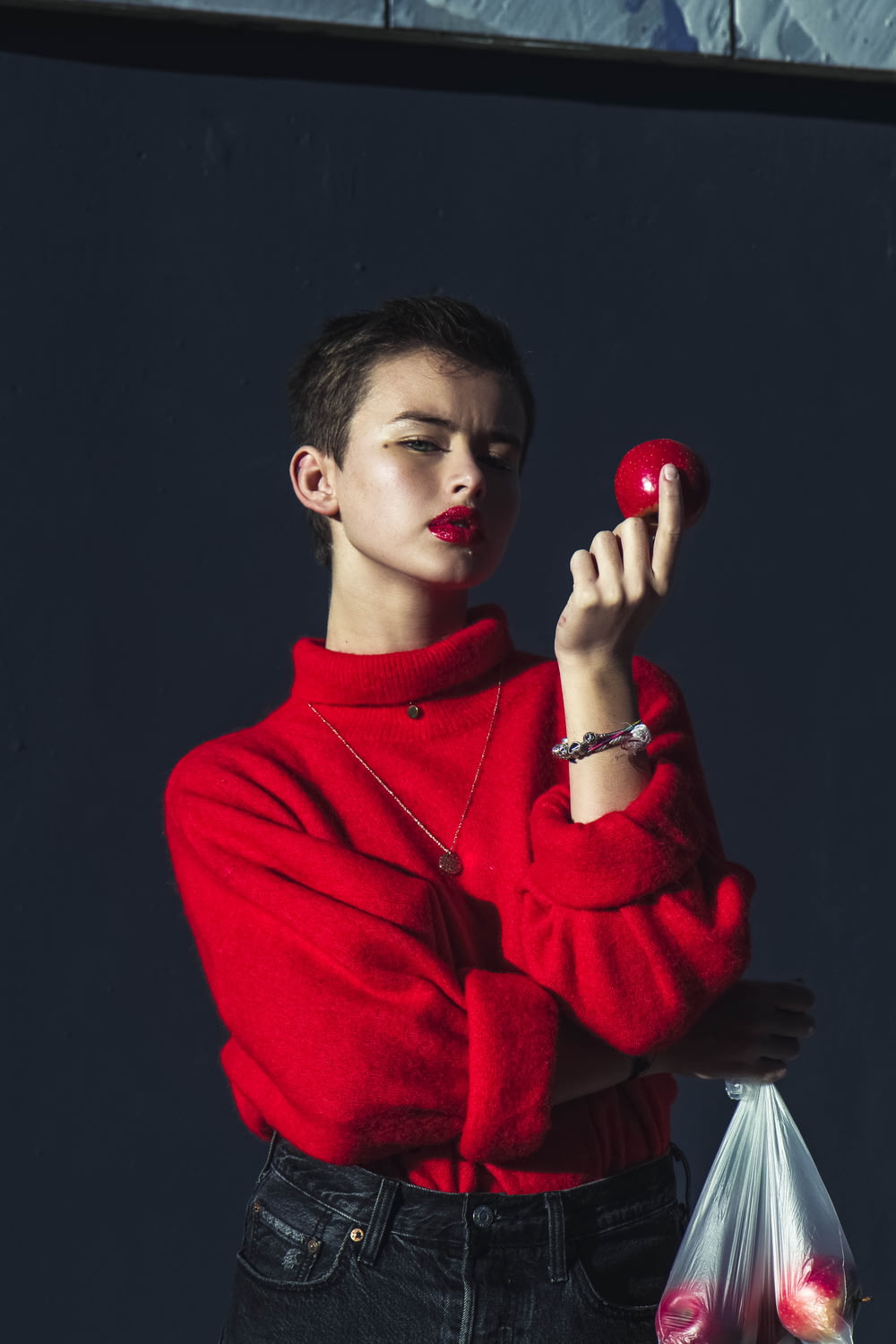 boy in red sweater holding red apple fruit