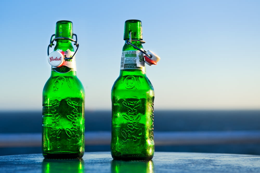 a couple of green bottles sitting on top of a table