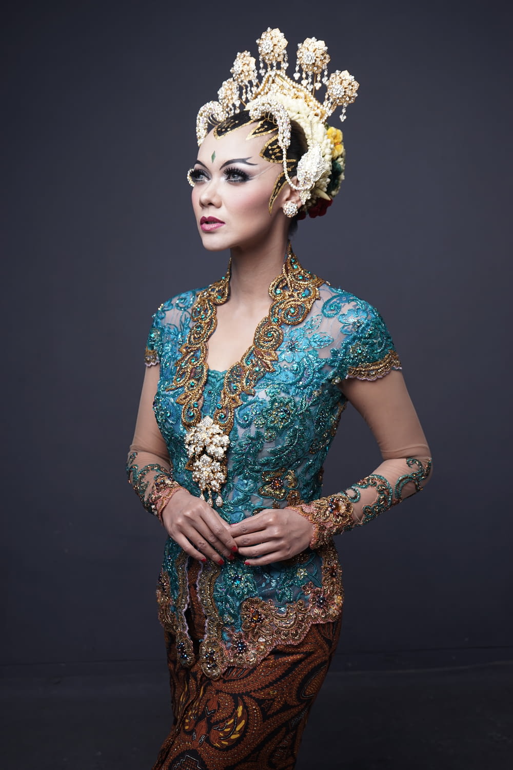woman in blue and brown floral dress wearing white floral headdress