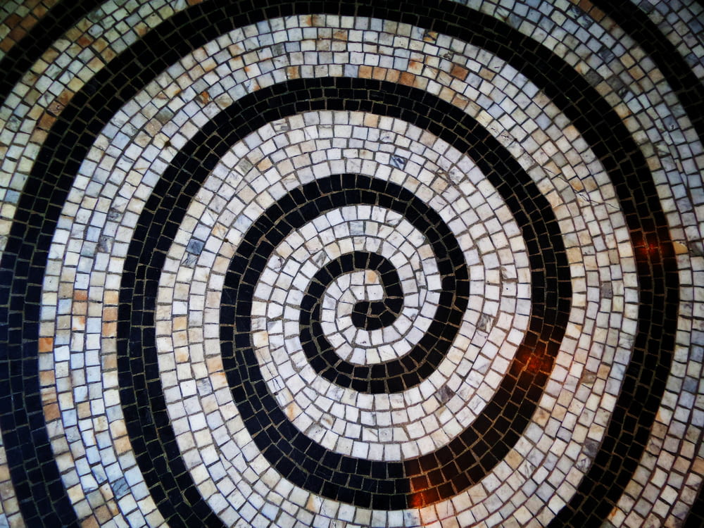 a black and white spiral pattern on a tile floor