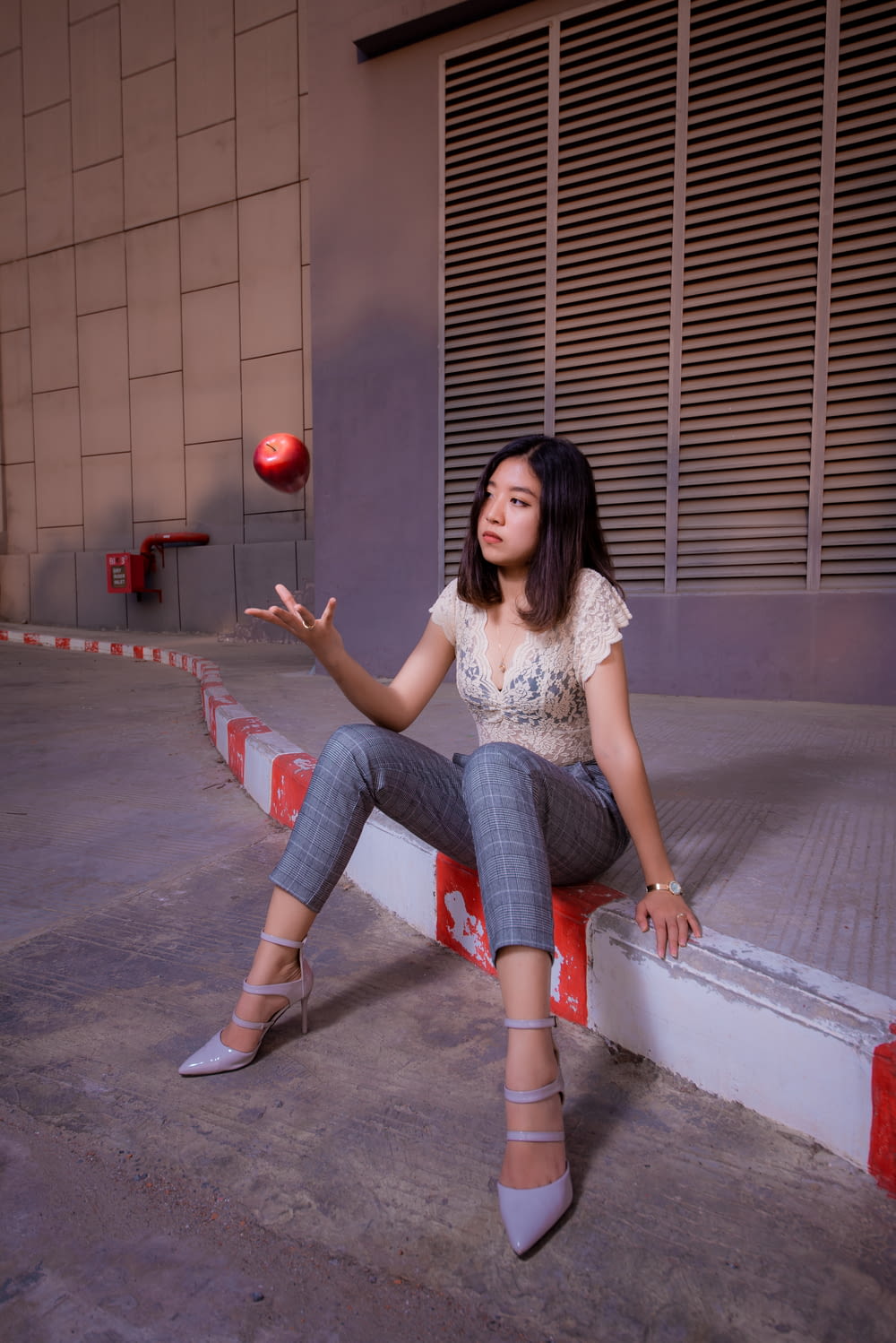 woman in white shirt and blue denim jeans sitting on white concrete bench