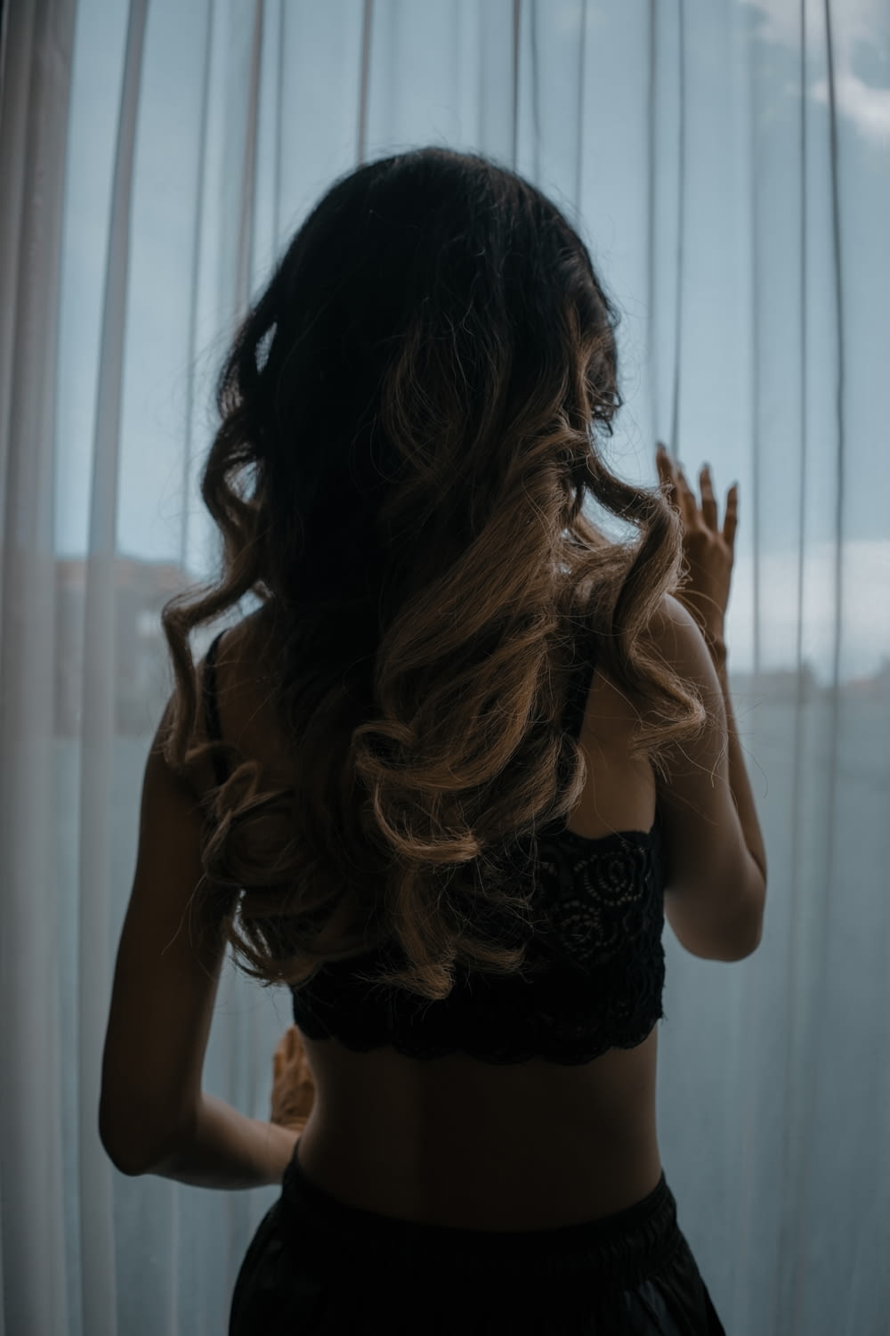 woman in black lace brassiere and panty standing near window