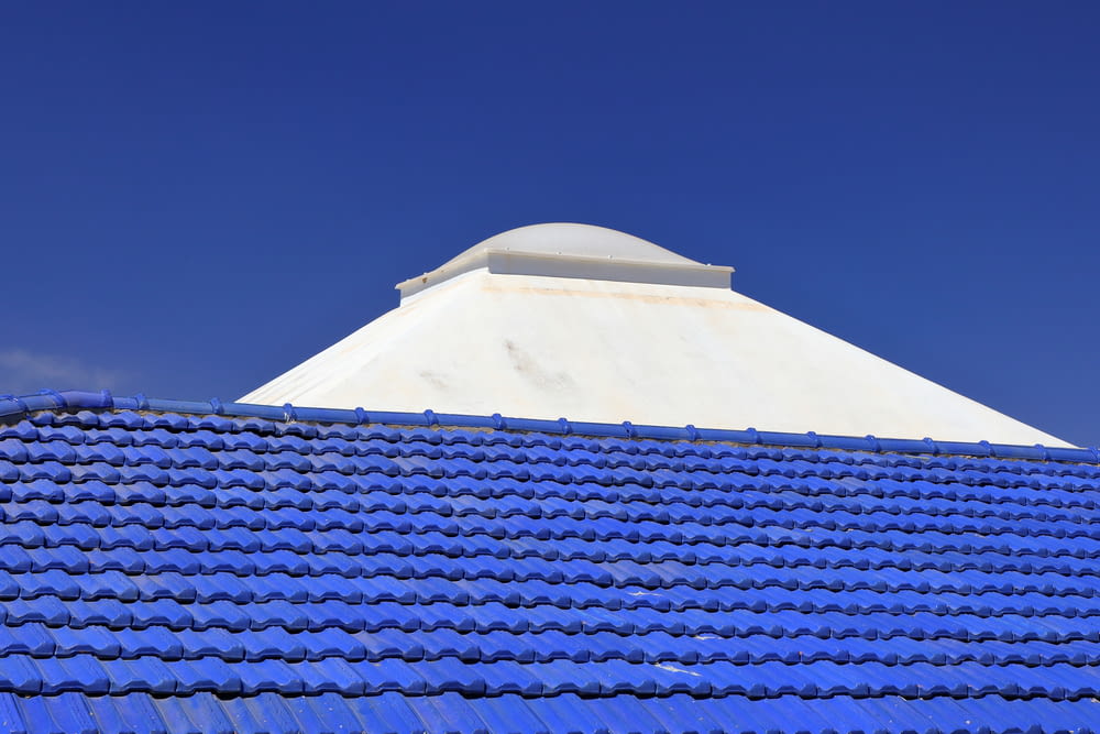a blue tiled roof with a white dome on top