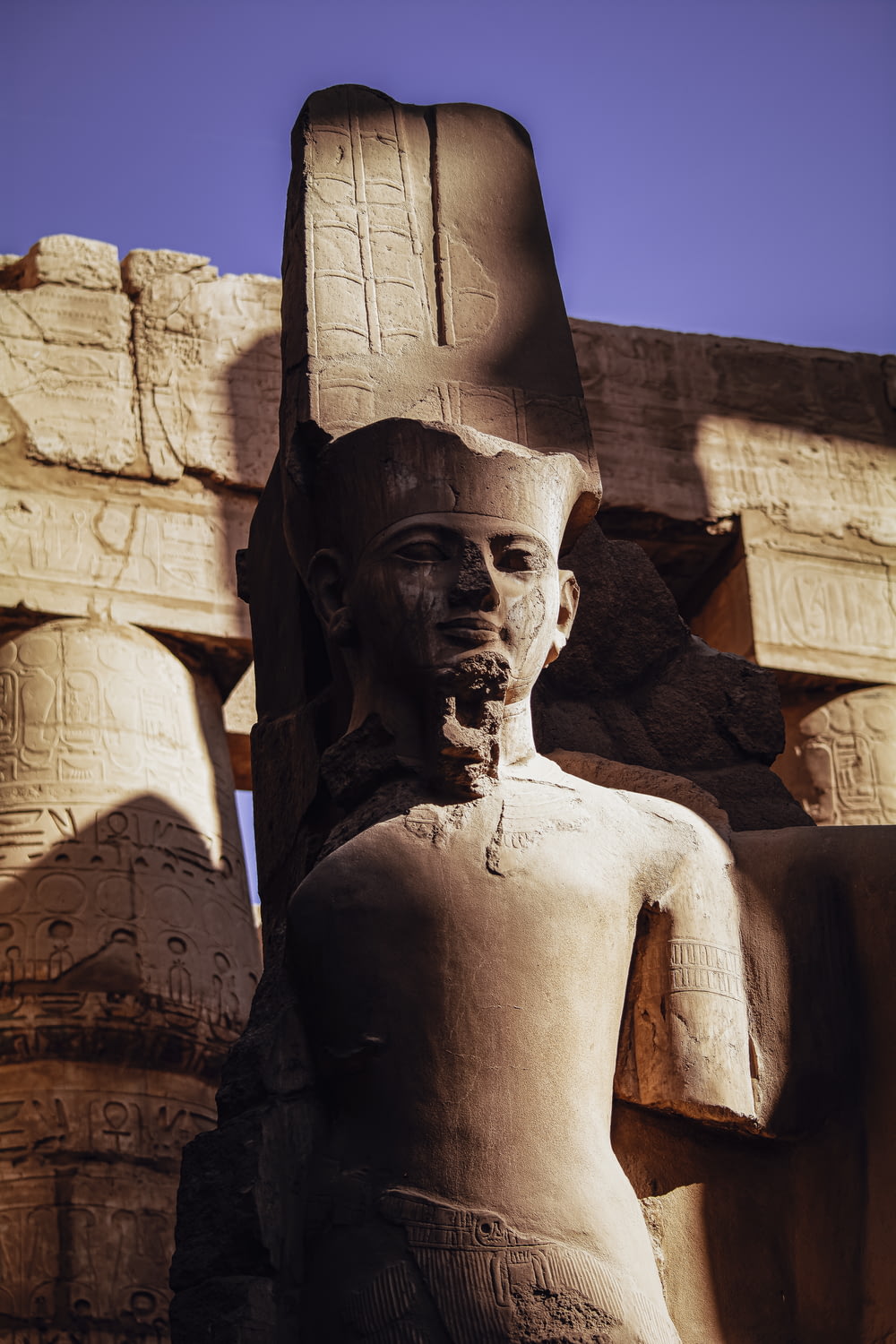 a statue of an egyptian god in front of a blue sky