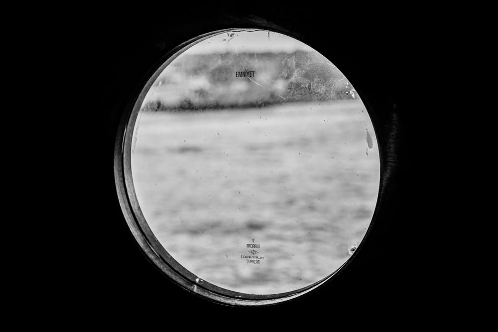 grayscale photo of round mirror