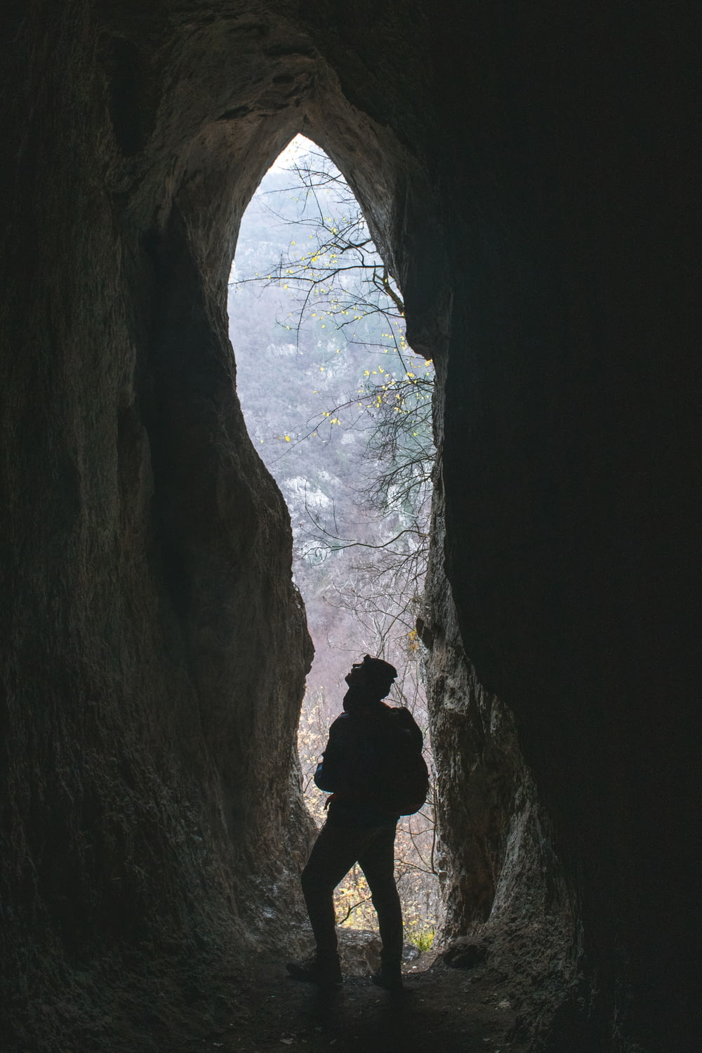 silhouette of man in cave during daytime