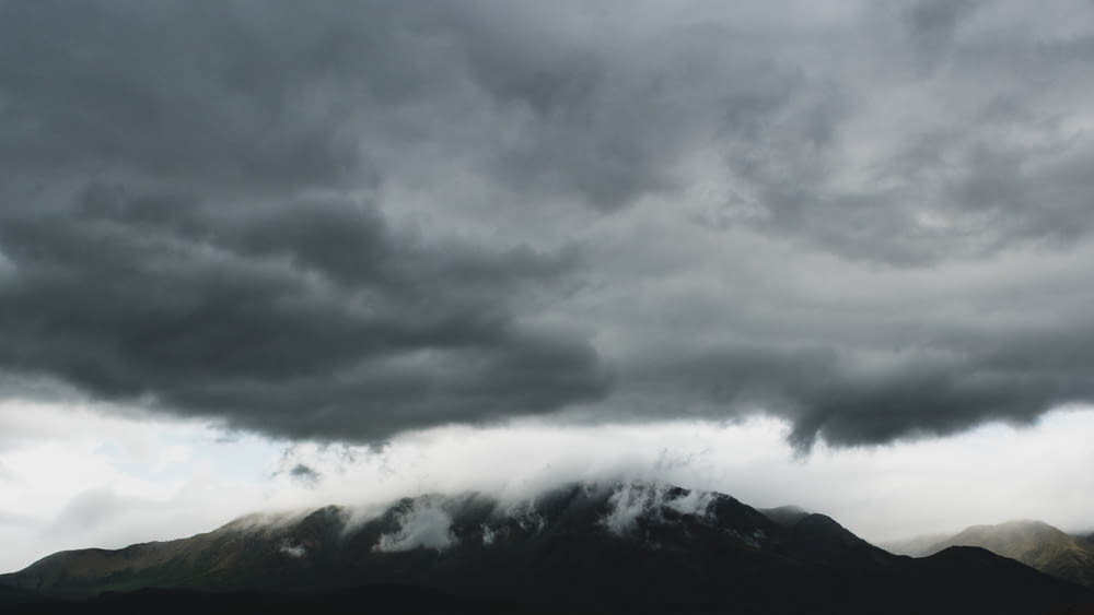 black and white mountain under gray clouds
