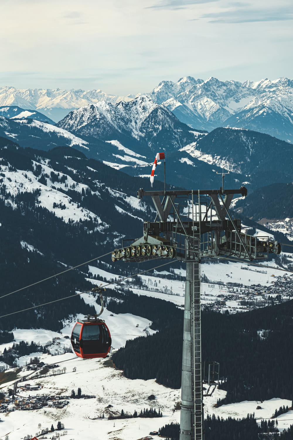 red and black cable car over snow covered mountain during daytime