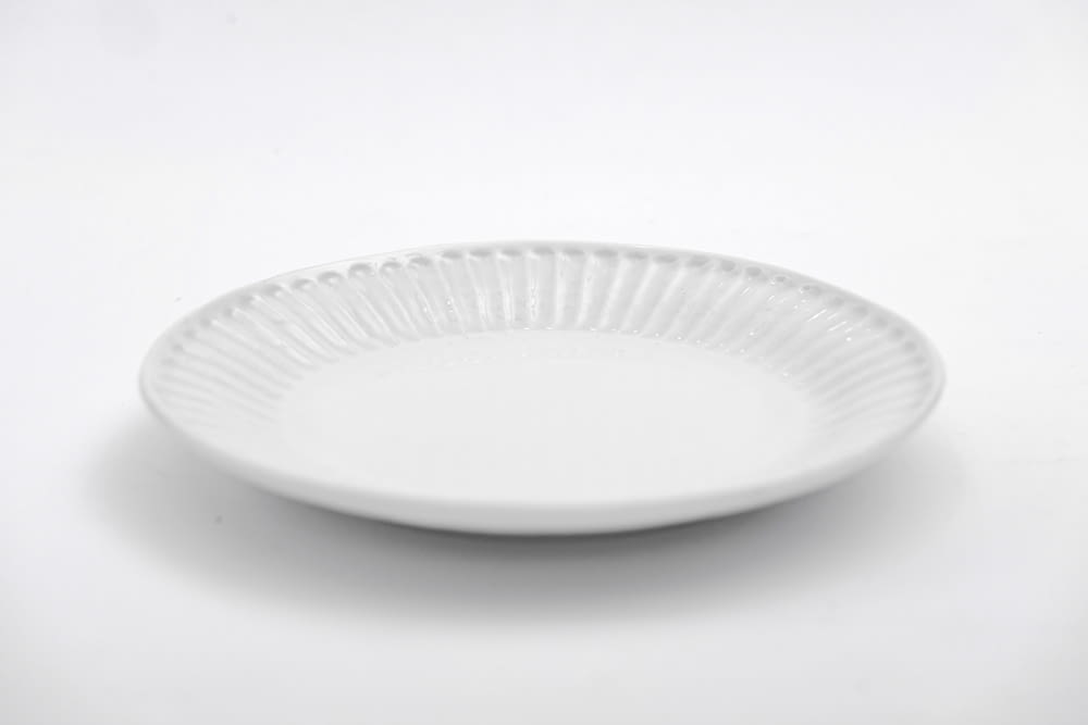 Plato redondo blanco sobre mesa blanca