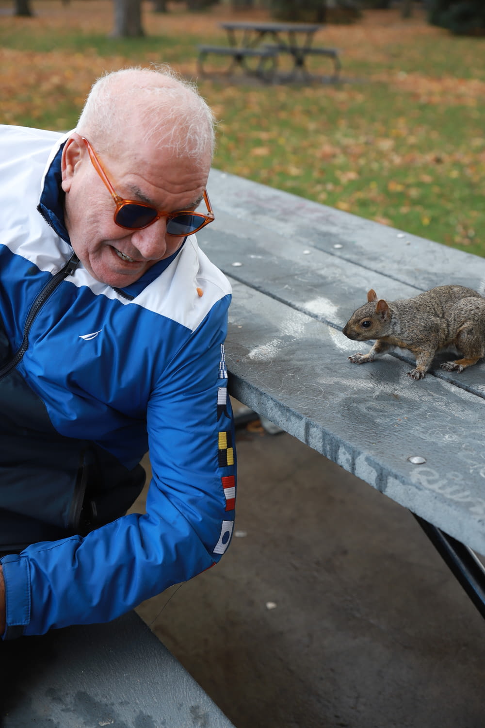 man in blue jacket holding squirrel
