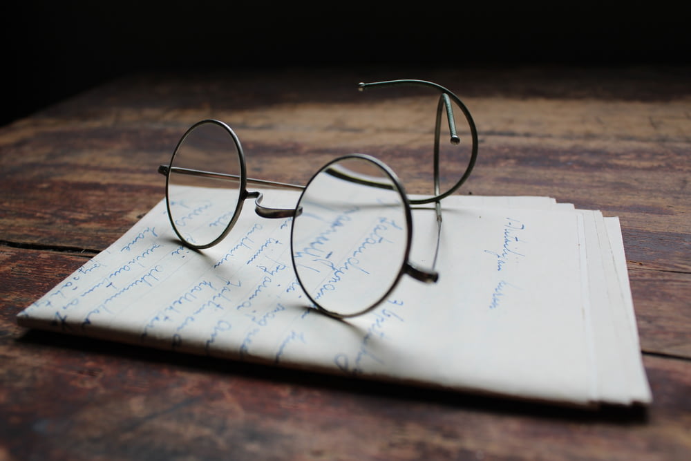 óculos de armação prateada em papel de impressora branco