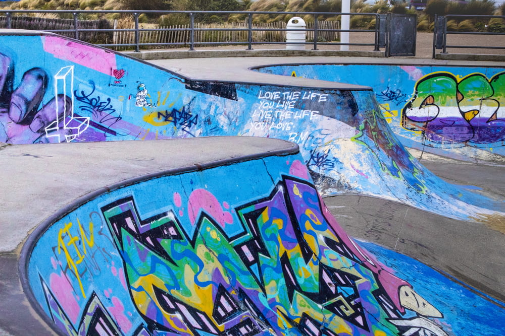 a group of skateboard ramps covered in graffiti