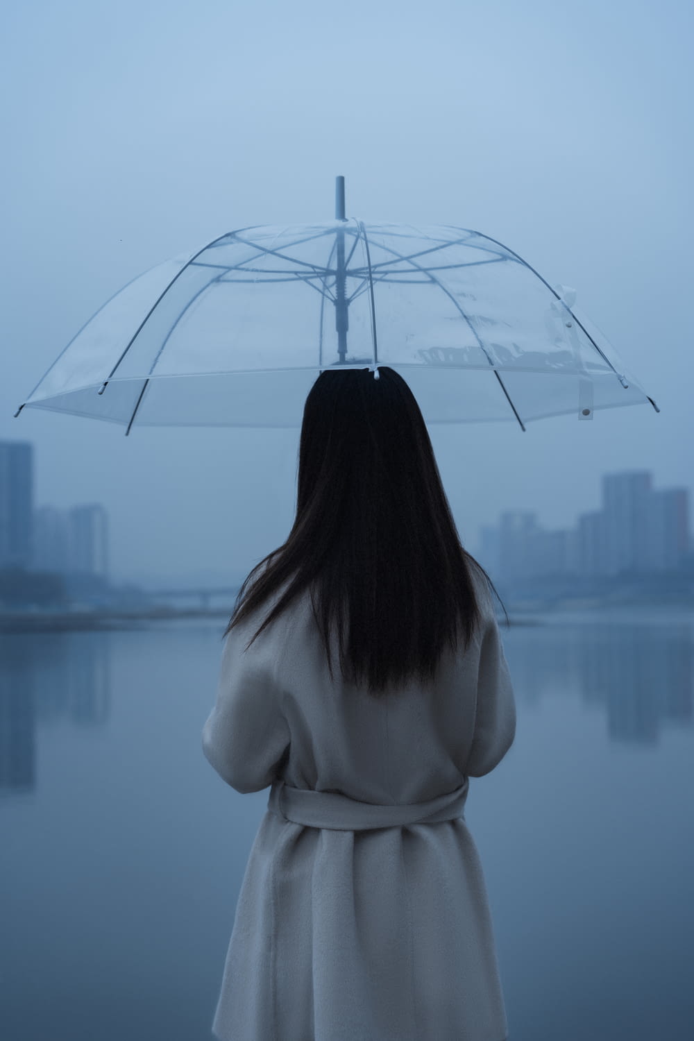 woman in white long sleeve shirt holding umbrella