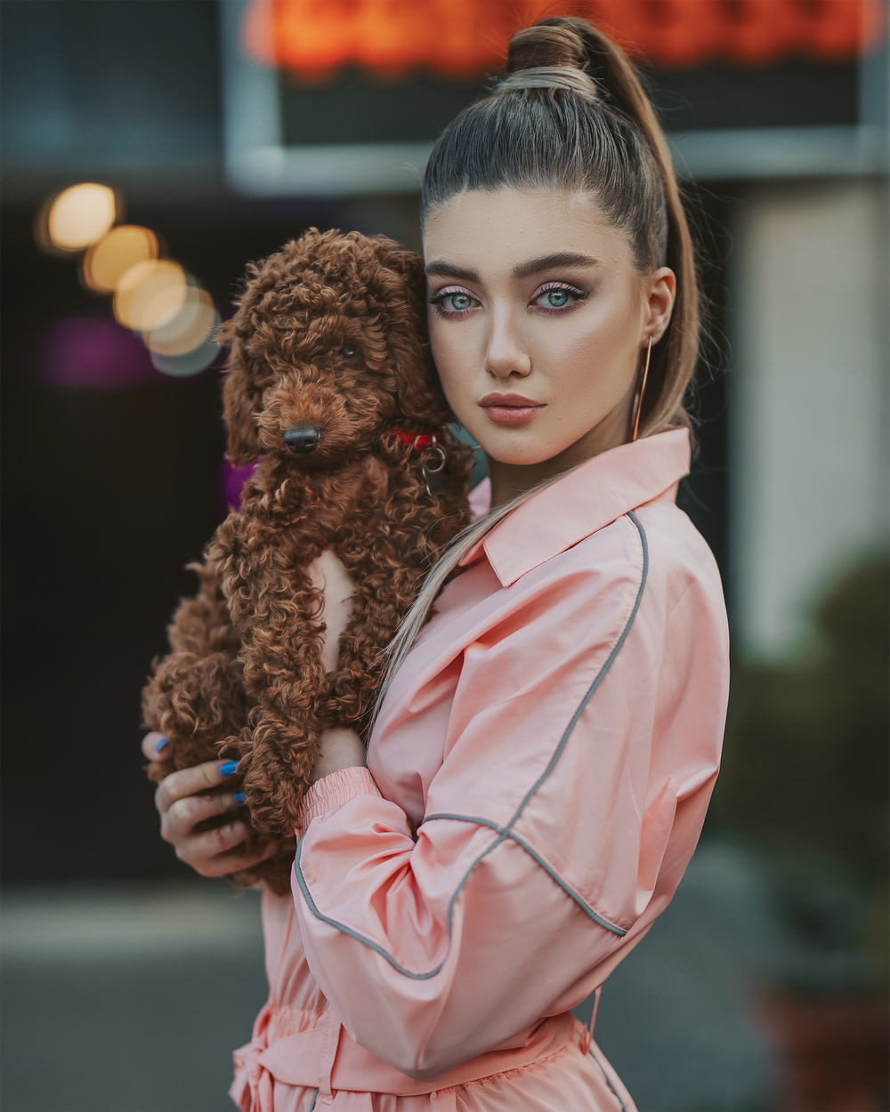 girl in pink coat holding brown dog