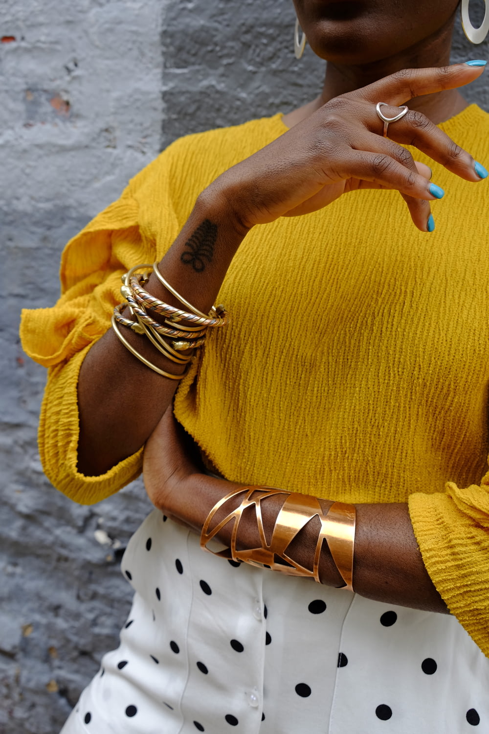 Femme en pull jaune portant un bracelet en or