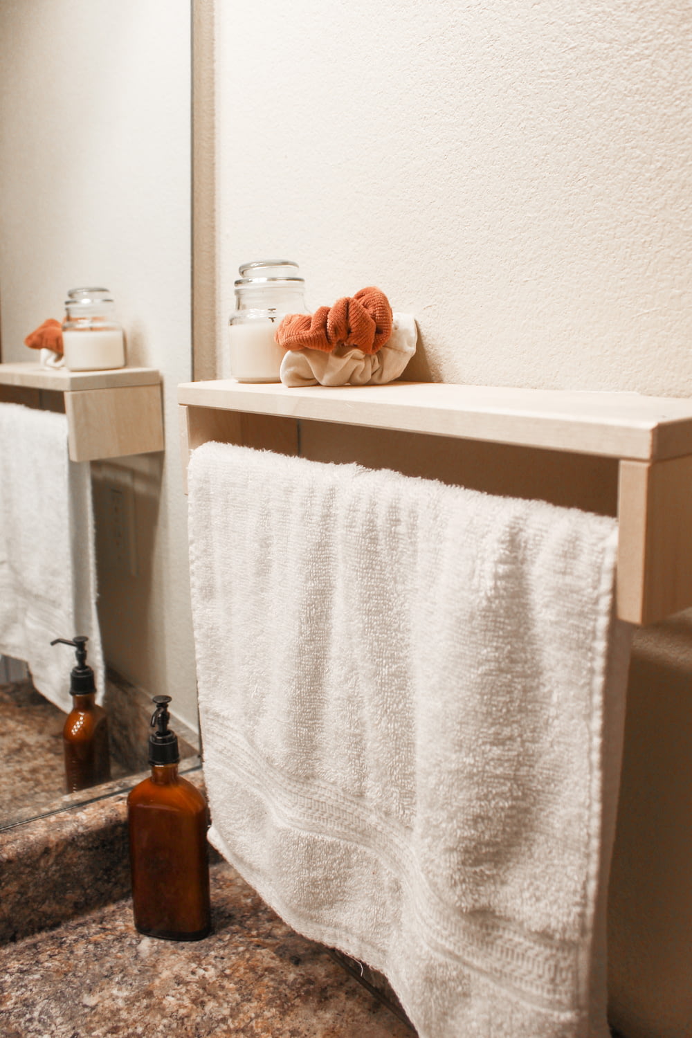 white bath towel on white wooden shelf