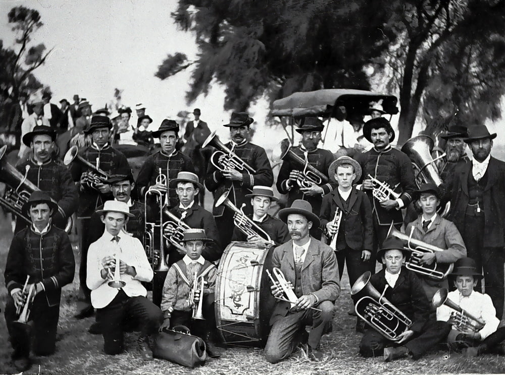Graustufenfoto von Männern mit schwarzem Hut beim Musikinstrument