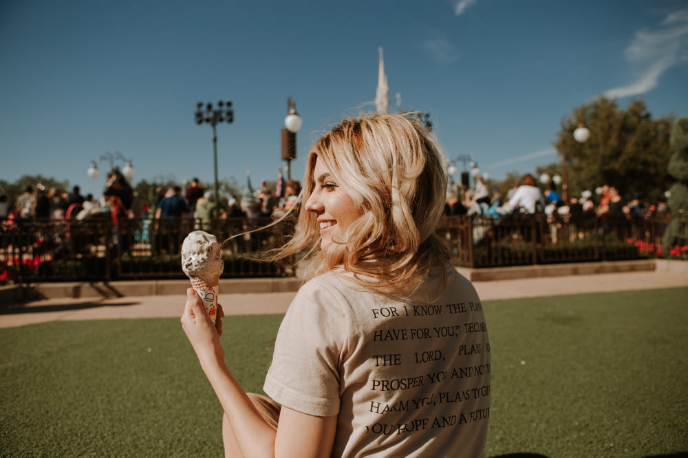 girl in white crew neck t-shirt holding ice cream cone