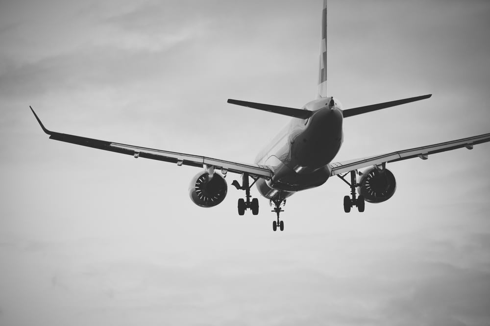 Photo en niveaux de gris d’un avion dans les airs