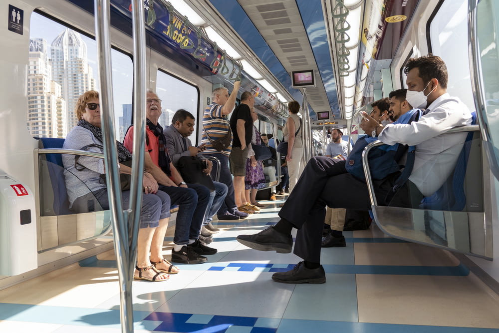 people sitting on blue and white train seat