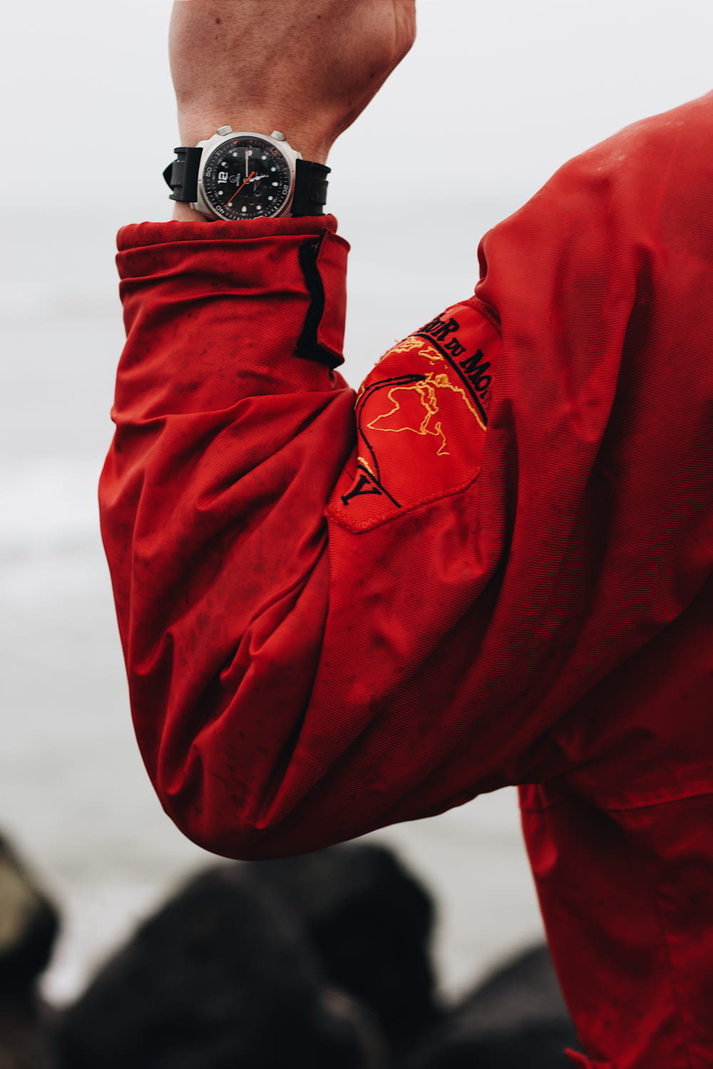 pessoa na jaqueta vermelha vestindo relógio preto e prata