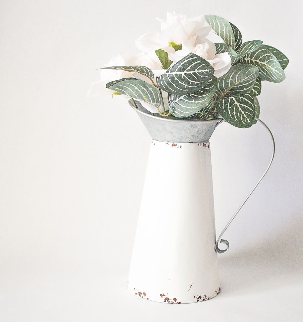 white and green flower in white ceramic vase