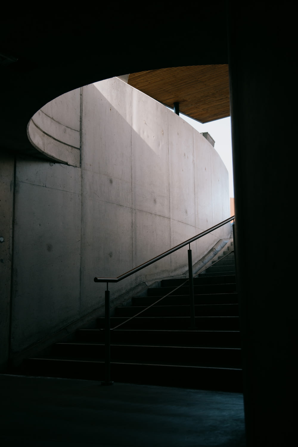白いコンクリートの壁に黒い金属の階段