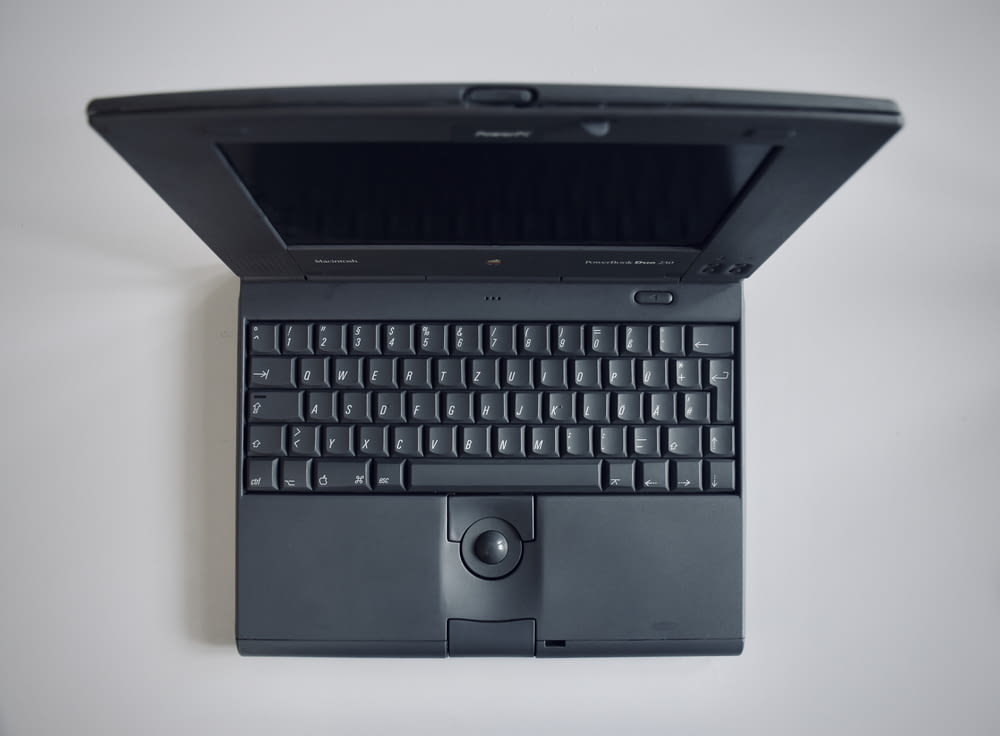black laptop computer on white table