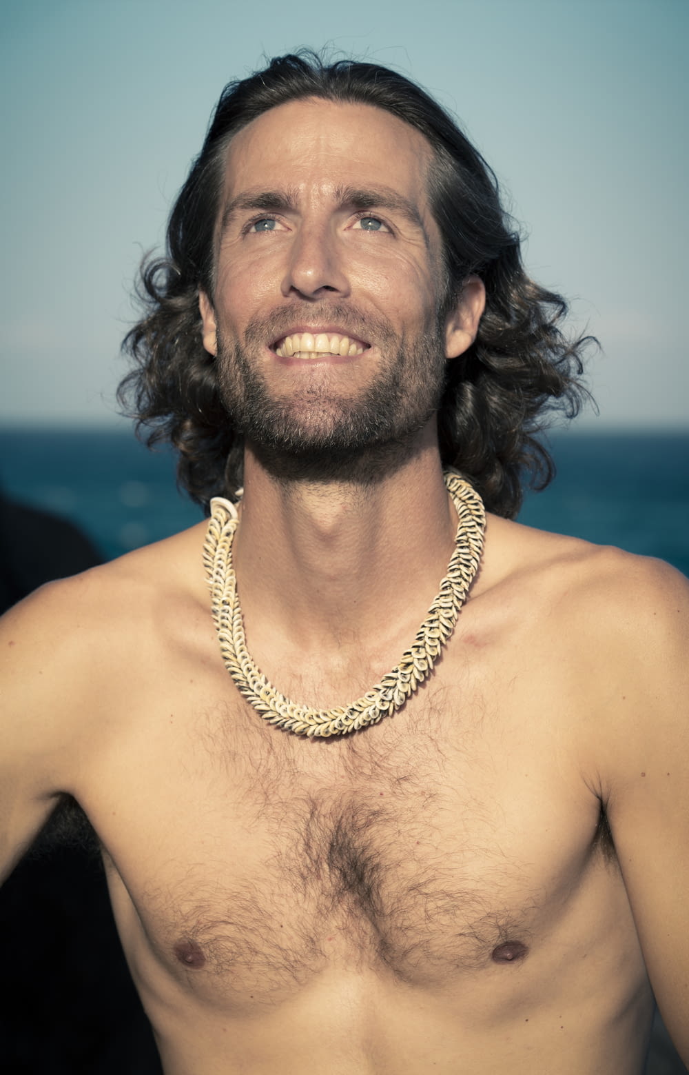 topless man wearing gold necklace