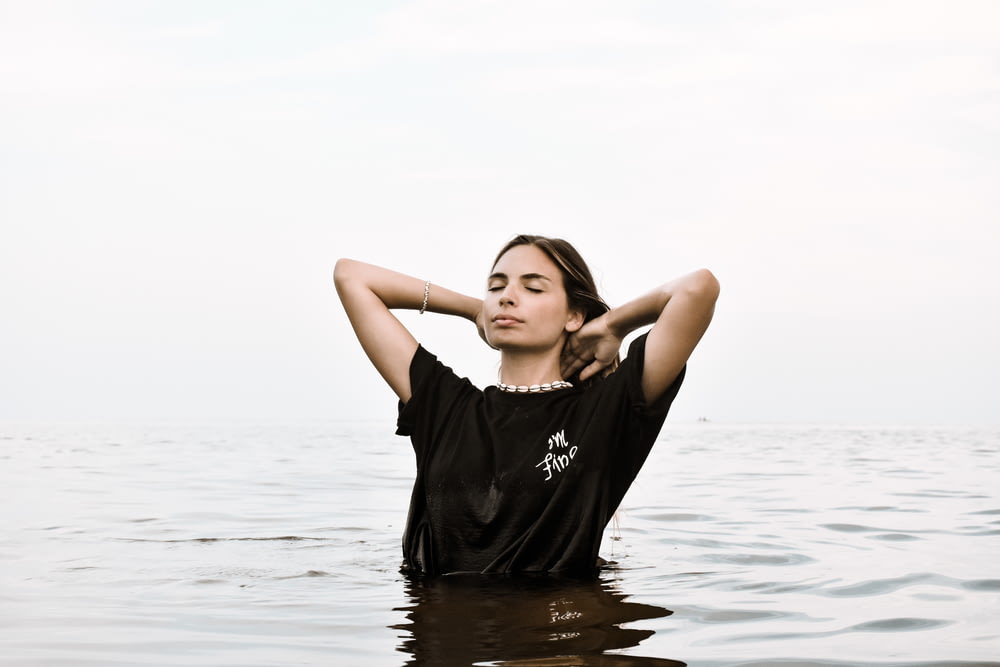 woman in black crew neck t-shirt standing on water during daytime