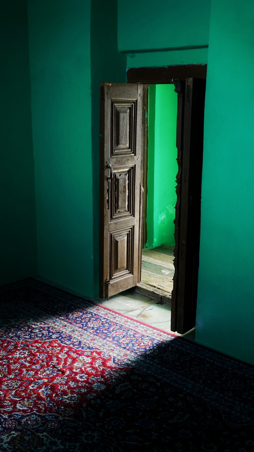 brown wooden door on green painted wall