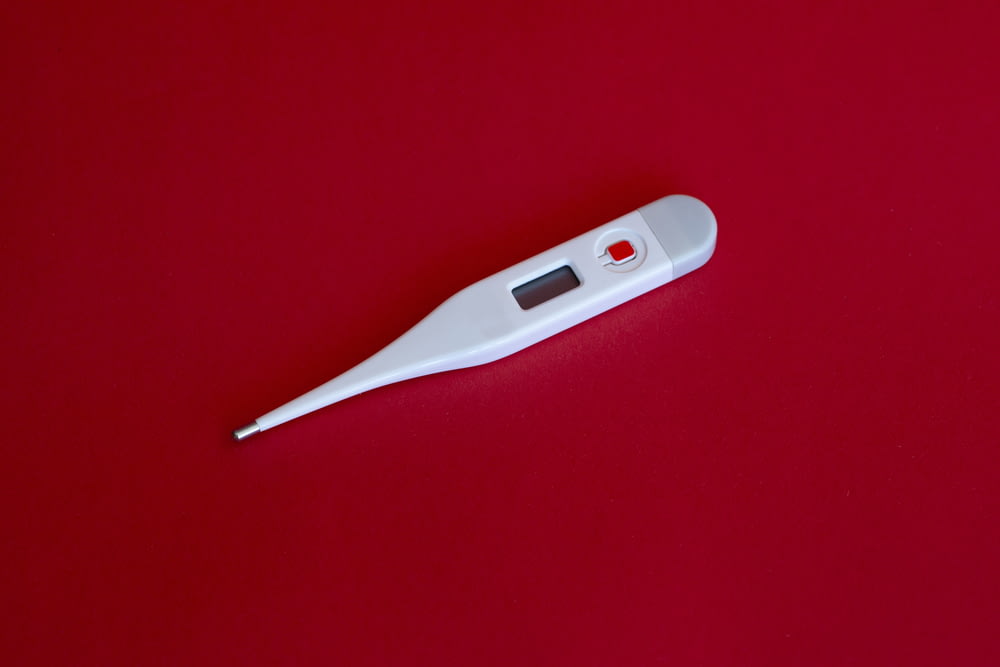 termometro bianco su superficie rossa